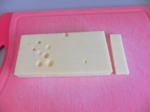 Cortamos el taco de queso emmental en lonchitas de este tamaño