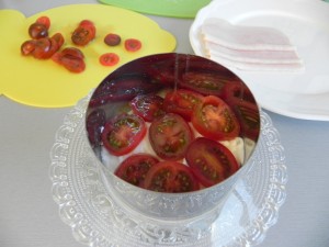A continuación, ponemos una capa de rodajas de tomate cherry