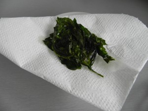 Un vez fritas las hojas de albahaca, las dejamos sobre papel de cocina para quitarles el exceso de garsa