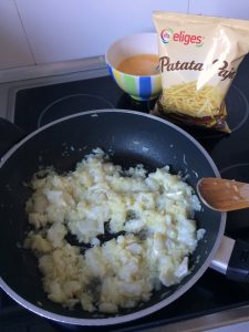 Tras dos minutos, añadimos las patatas paja y los huevos