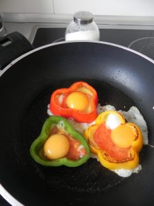 Cuando esté hecho el tomate. añadimos en cada flor un huevo y sazonamos. Lo dejamos cocinar hasta que el huevo se cuaje.